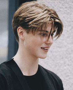 a young man wearing a black shirt and smiling