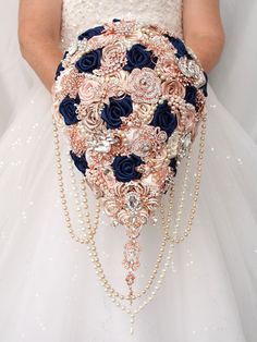 a bridal holding a wedding bouquet made with pearls and flowers on it's back