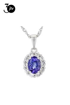 1.25ct Oval Tanzanite With 0.85ctw Round White Zircon Rhodium Over Sterling Silver Pendant With 18"Singapore Chain. Measures Approximately 0.74"L x 0.37"W. 2.5mm bail. Lobster clasp with 2"extender. Accent stones primarily zircon. Gia Certified Oval Silver Necklace, Oval Tanzanite Jewelry With Halo Design, Formal Oval Necklaces With Center Stone, White Gold Tanzanite Oval Necklaces, Oval White Gold Necklace With Center Stone, Blue Tanzanite, Pendant With Chain, Sterling Silver Pendant, Sterling Silver Pendants