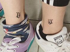 two people with matching tattoos on their feet, one has a penguin and the other has a penguin