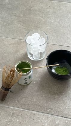 two bowls with green tea and whisk on the floor next to each other