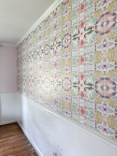 an empty room with wallpaper and wood flooring