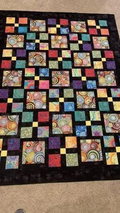 a colorful quilt is laying on the floor