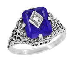 This dramatic Art Deco filigree lapis ring features a lovely emerald cut lapis lazuli gemstone as the background for a securely four prong set shimmering 0.01 round natural single cut diamond in a diamond shaped setting. Sure to be noticed, this beautiful vintage daylight ring replica is crafted in sterling silver pierced filigree and hand finished with intricate detail in a scrolls, flowers, and leaves pattern with an antiqued finish. This original Carolines ring style was purchased directly fr Vampire Ring, Daylight Ring, Thick Silver Ring, Art Deco Filigree, Lapis Lazuli Jewelry, Lapis Ring, Caroline Forbes, Lapis Lazuli Ring, Silver Stacking Rings