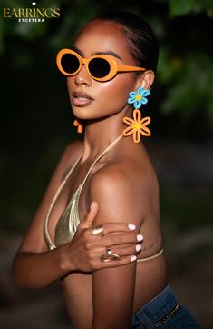 Introducing NOLA STATEMENT EARRINGS, the perfect accessory for a day at the beach. These eye-catching earrings feature a bright and colorful floral design that is sure to make a statement. With their vibrant colors and unique design, these earrings will add a touch of fun and playfulness to any outfit. Elevate your style and brighten up your day with these stunning earrings.