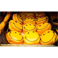 many yellow smiley face cookies with black dots on them are arranged in the shape of smiling faces