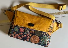 A belt bag that converts to an easy to wear style across the body. The bag has a flap entry with an interior zippered pocket and a zippered pocket on the reverse of the bag. Great bag for travel or errand running. Cotton webbing strap adjusts to length. Body of bag and flap are comprised of cork (mustard and floral version). The lining is a quality cotton print. Measures approximately 10"x 7" by 2" deep. Gunmetal hardware with flip lock closure. please make choice from menu. Cow print version is Versatile Satchel Belt Bag With Removable Pouch, Travel Belt Bag Satchel With Removable Pouch, Travel Belt Bag With Detachable Strap, Versatile Crossbody Belt Bag With Zipper Pocket, Versatile Satchel Belt Bag With Zipper Pocket, Versatile Satchel Belt Bag For Mobile Phone, Versatile Mobile Phone Satchel Belt Bag, Casual Belt Bag With Detachable Strap For Travel, Travel Belt Bag Satchel With Cell Phone Pocket