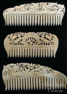 three white combs with carved designs on them