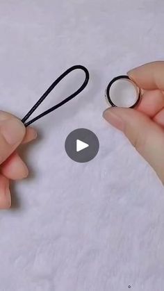 two hands holding scissors and string on top of a sheet of white paper with the video below it