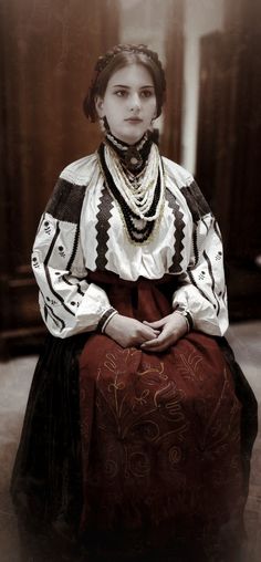 an old photo of a woman sitting on the floor with her hands folded in front of her chest