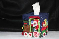 a tissue dispenser with a santa clause on the front and a train design on the back