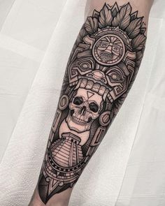 a man's leg with a tattoo on it that has a skull and sunflowers