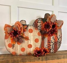 two decorative pumpkins sitting on top of a wooden shelf