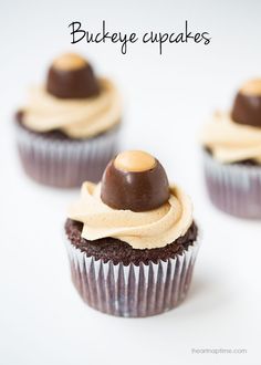 three cupcakes with peanut butter frosting on top and topped with a chocolate ganache