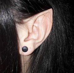 a woman's ear is shown with two black dots on the top of it