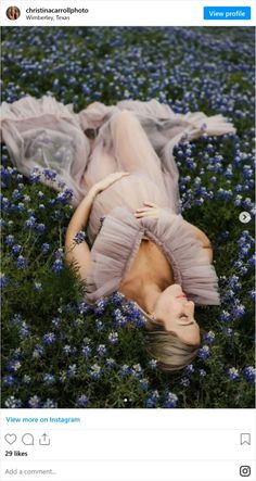 a woman laying on her back in a field of blue flowers with the caption instagram