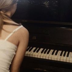 a woman standing in front of a piano