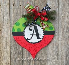 a christmas ornament hanging on the side of a wooden fence with a bow