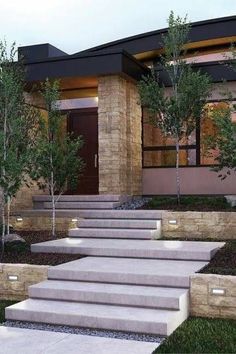 a modern house with stone steps leading to the front door