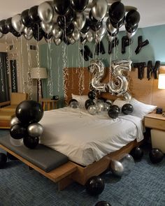 a bedroom decorated with balloons and streamers in the shape of numbers