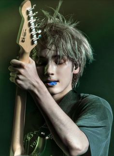 a young man holding a guitar in his hands