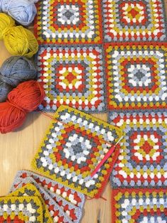 crocheted granny afghans and balls of yarn on a table