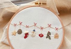 an embroidered christmas ornament hanging from a hoop