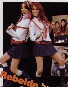 two girls in school uniforms are posing for the camera