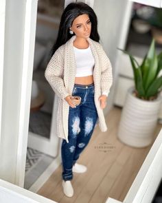 a barbie doll is standing in the doorway with her hands on her hips and looking at herself