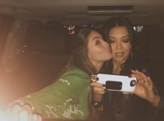 two women are kissing in the back of a car