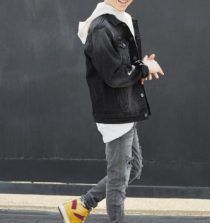 a young man walking down the street wearing yellow shoes