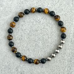 Men's beaded bracelet made with strong, stretchy cord and genuine/natural gemstones. Features ~ 6mm matte onyx beads  ~ 6mm yellow tiger eye beads. Also available in blue, red, green purple and aqua blue tiger eye.      Please send a message to customize. ~ 6mm stainless steel beads ~ 4mm black hematite spacers ~ Stretchy cord; simply slide bracelet on and off wrist ~ Comes packaged in a reusable micro fibre pouch To ensure the perfect fit, please use the bracelet sizing instructions found in th Adjustable Onyx Stretch Bracelet With Gemstone Beads, Adjustable Onyx Stretch Bracelet With Round Beads, Hand-strung Adjustable Onyx Stretch Bracelet, Adjustable Onyx Bracelet For Healing, Adjustable Onyx Stretch Bracelet For Healing, Onyx Gemstone Beads Stretch Bracelet, Hematite Gemstone Beads Stretch Bracelet, Mens Bracelet Black, Man Bracelet