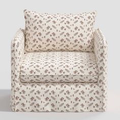 an upholstered chair with a flowered pattern on the back and arms, against a white background