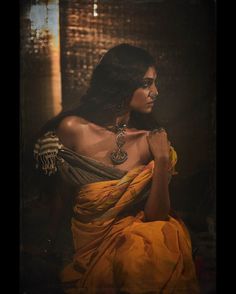 a woman in an orange sari sitting down