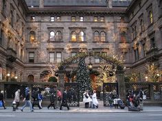 people walking in front of a large building decorated for christmas