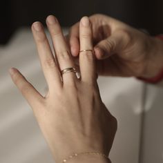 a woman's hand with a gold ring on her left and a diamond band on her right