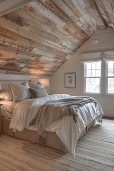 a bed sitting under a wooden ceiling in a bedroom next to two lamps and a window