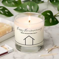 a white candle sitting on top of a table next to matches and a box of matches