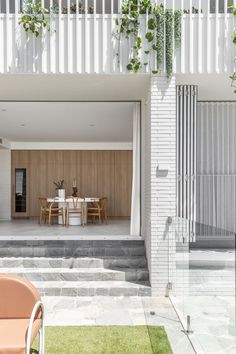 an outdoor dining area with patio furniture and potted plants on the side of the house