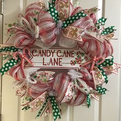 a candy cane wreath hanging on the front door for someone's christmas ornament