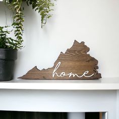 a wooden state shaped sign with the word home on it