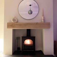 a wood burning stove with a mirror above it