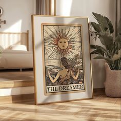 a framed poster on the floor in front of a potted plant with a sun above it