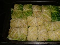 cabbage wrapped in leafy vegetables sitting on top of a pan