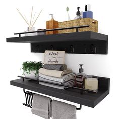 two black shelves with towels, soaps and other items on them in the bathroom