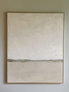 a painting hangs on the wall above a bed in a room with white walls and flooring