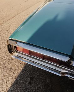 the rear end of an old car parked on the street