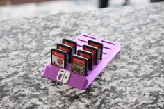 a purple holder with four nintendo wii game systems in it on a granite counter top