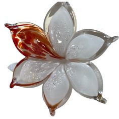 a flower shaped glass object with water droplets on it's petals and leaves, against a white background