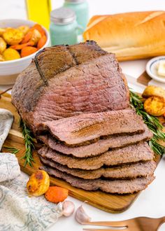 a pile of sliced meat sitting on top of a cutting board next to other food